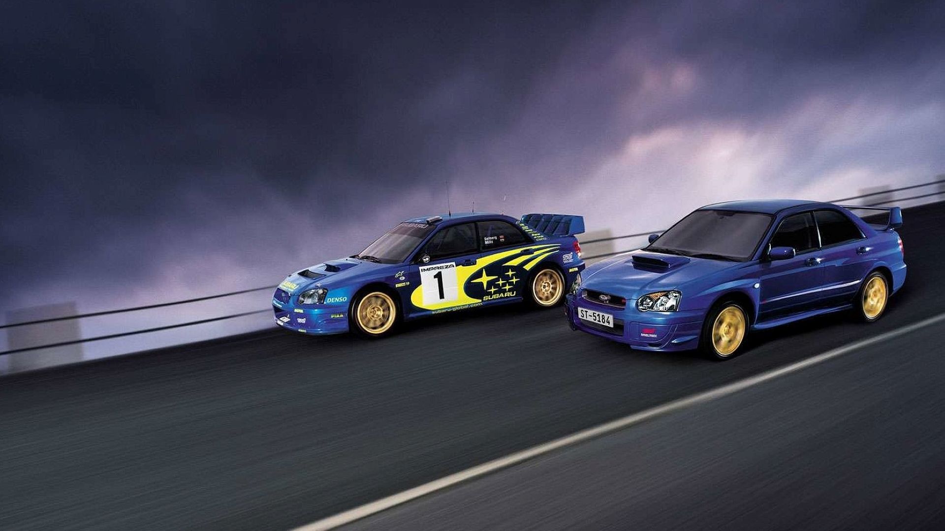 Side shot of the 2004 Subaru Impreza WRX STi next to its rally champ sister