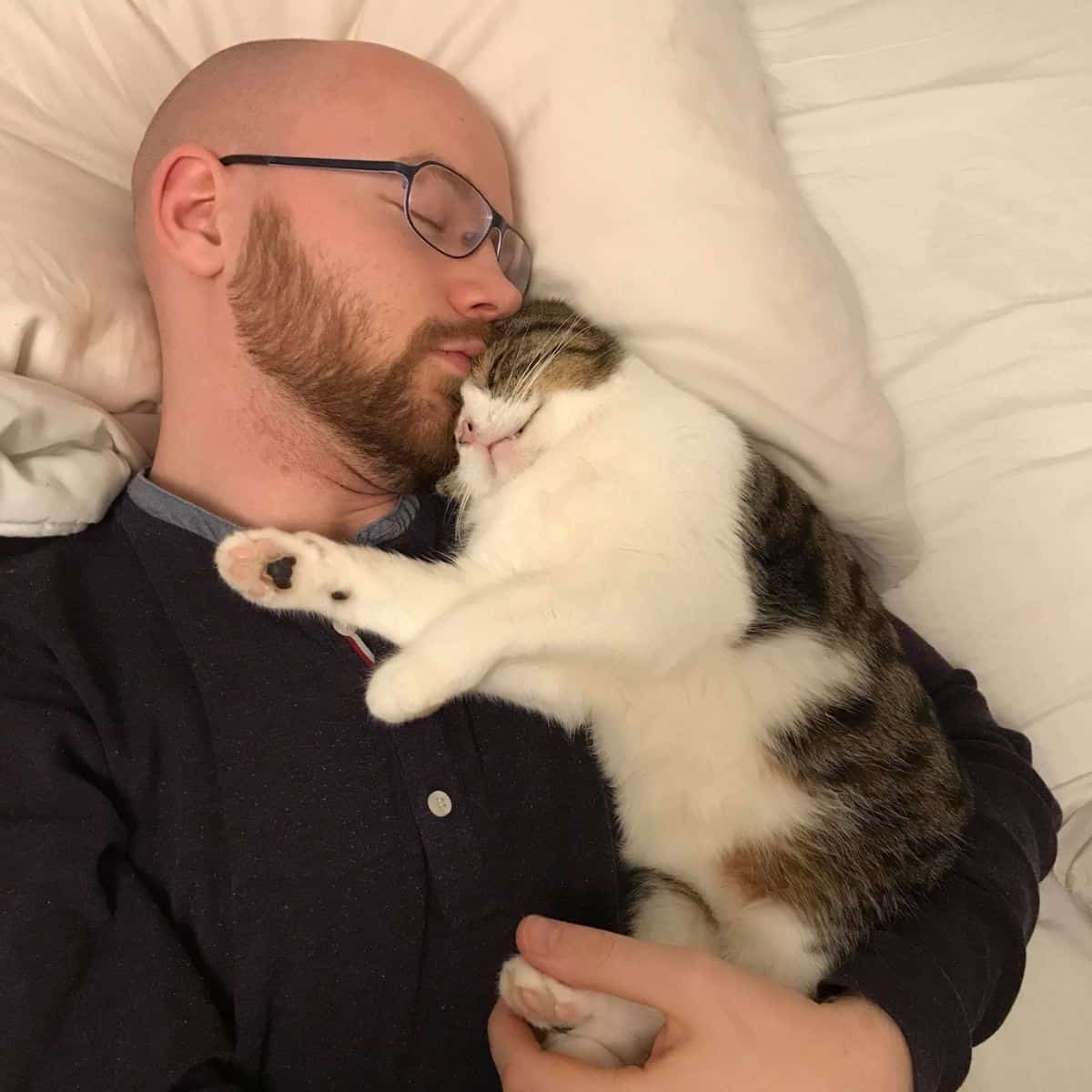 man sleeping with cat