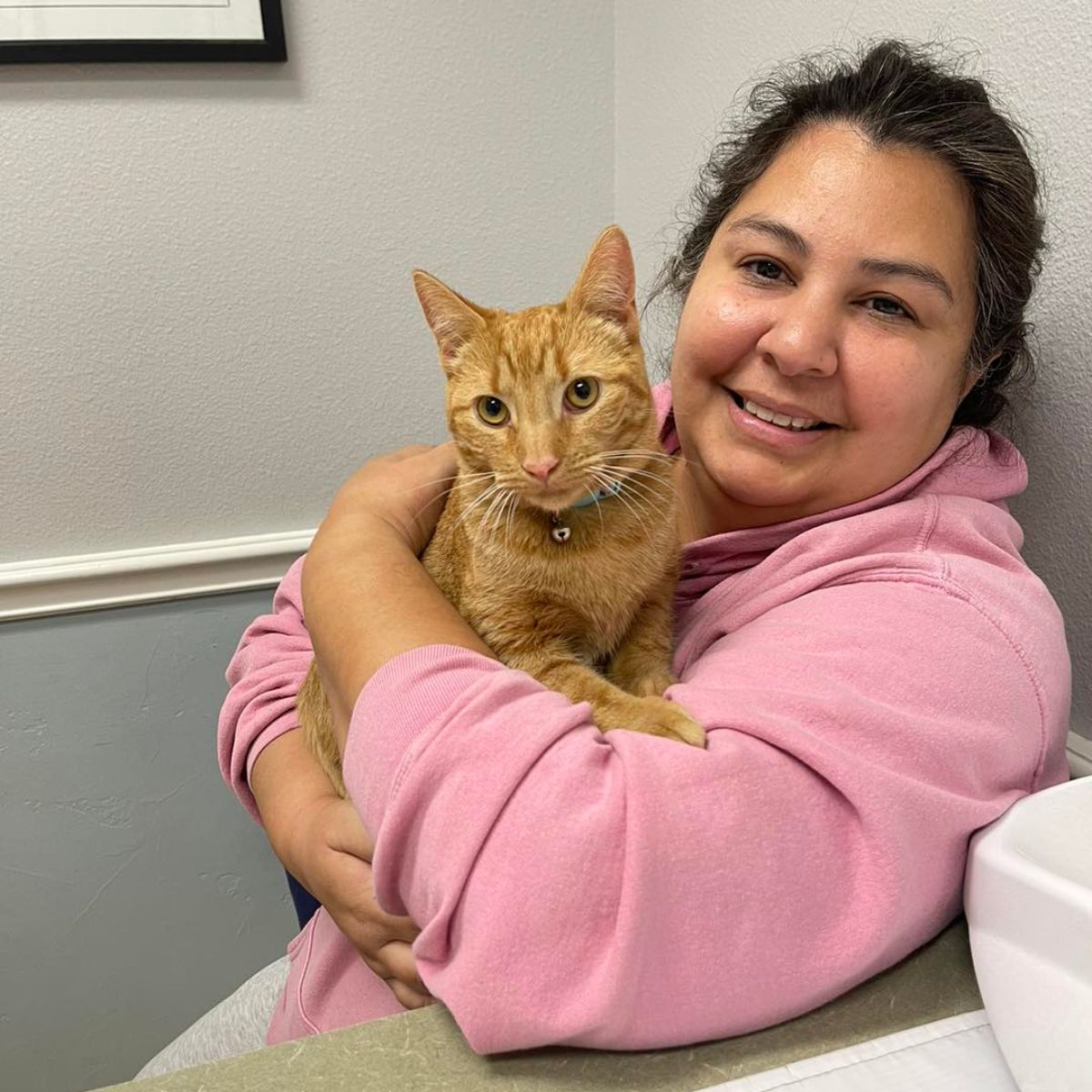 woman holding a ginger cat