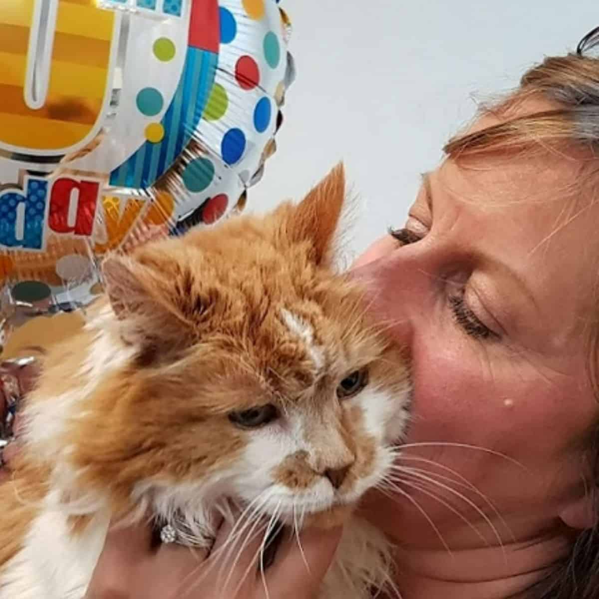 woman kissing cat