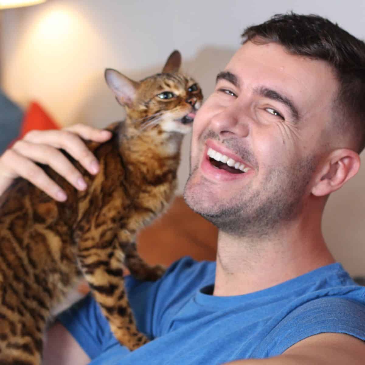 cat licking man's cheek