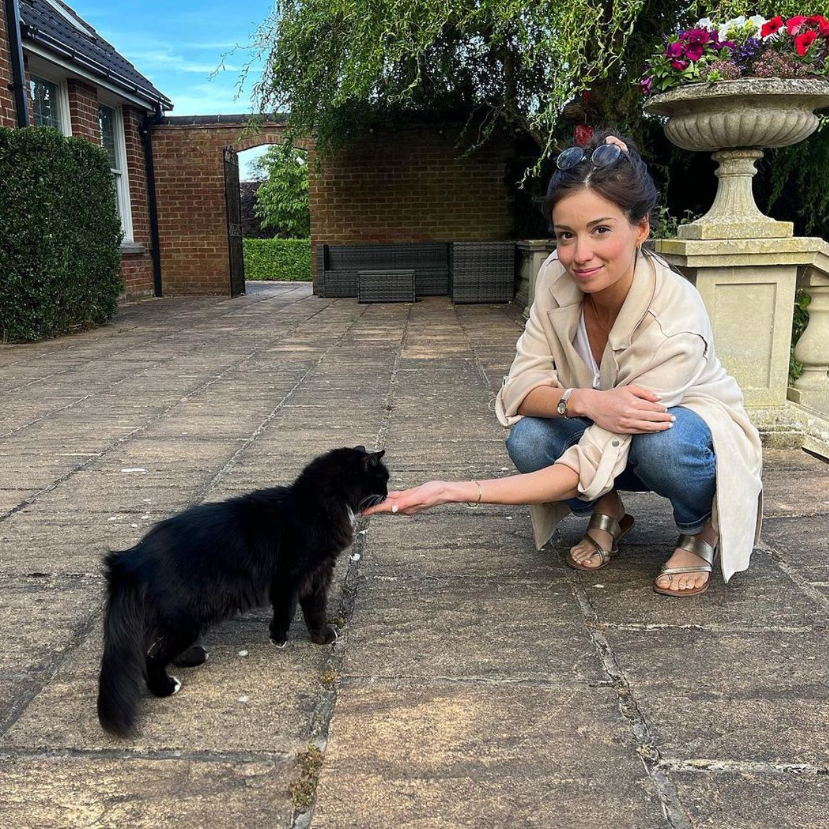 cute woman petting a black cat