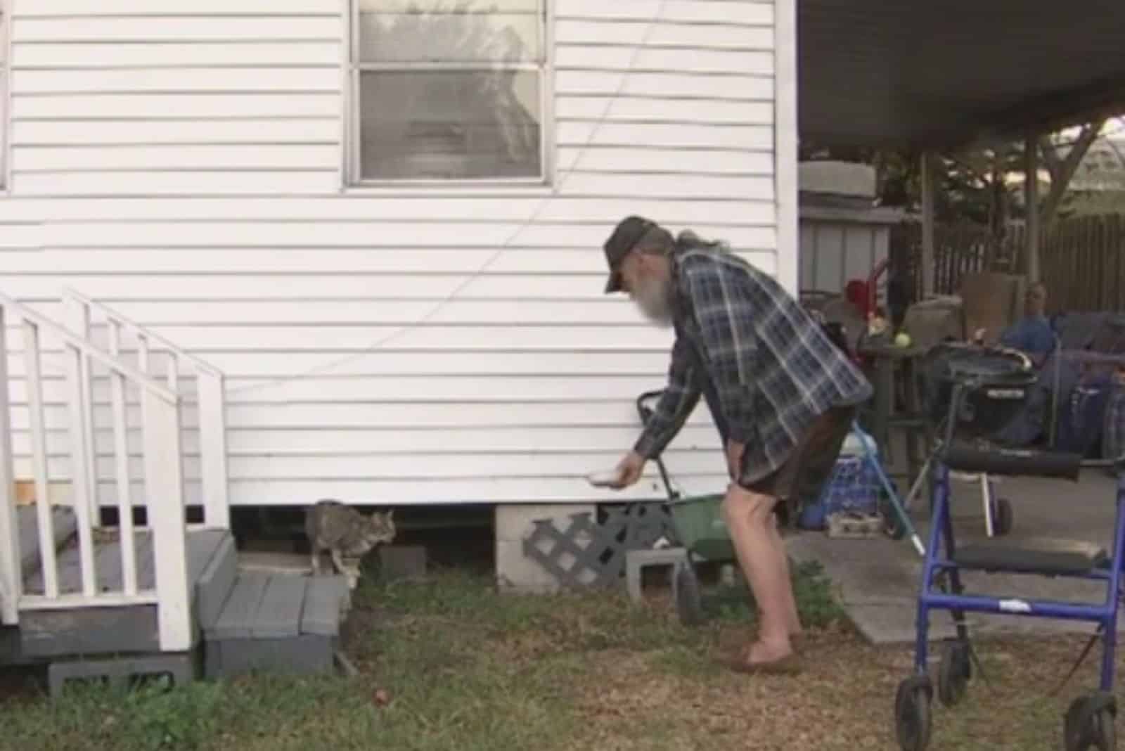 old guy feeding the cat