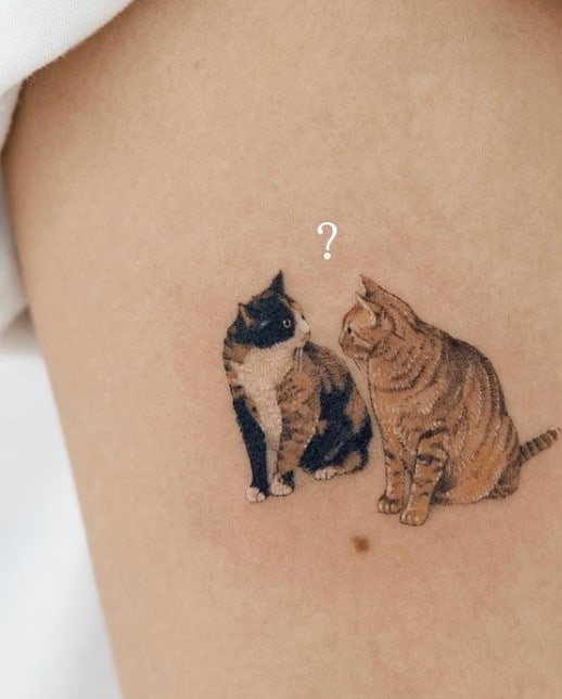 tattoo of two cats looking at each other