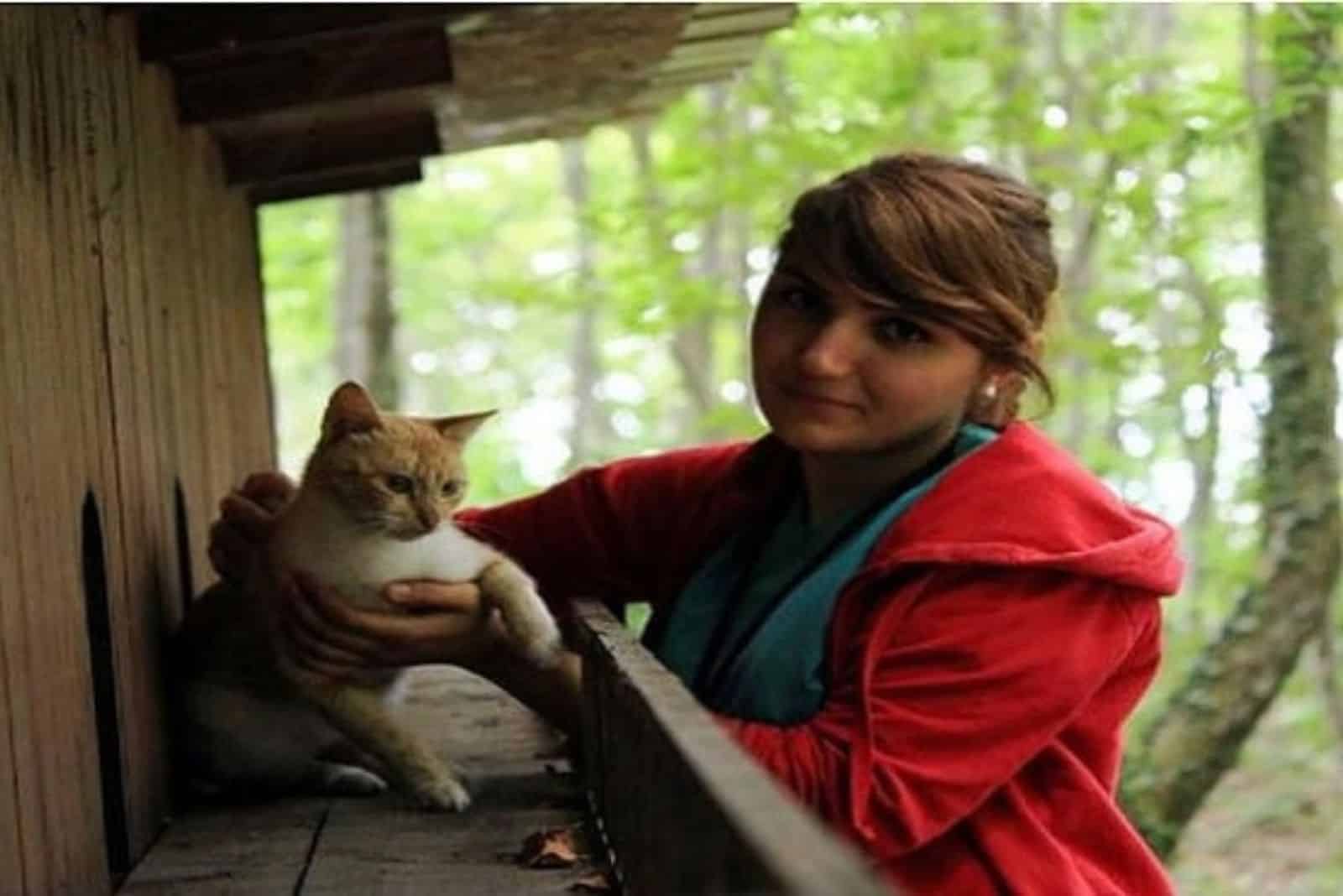 woman holding a white and yellow cat