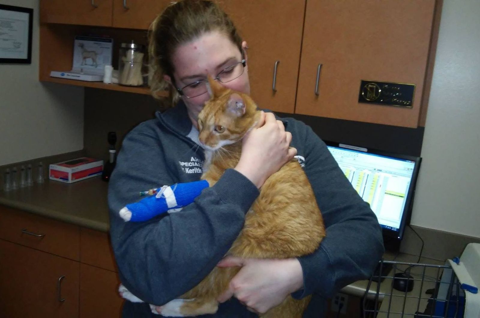 woman holding and kissing cat