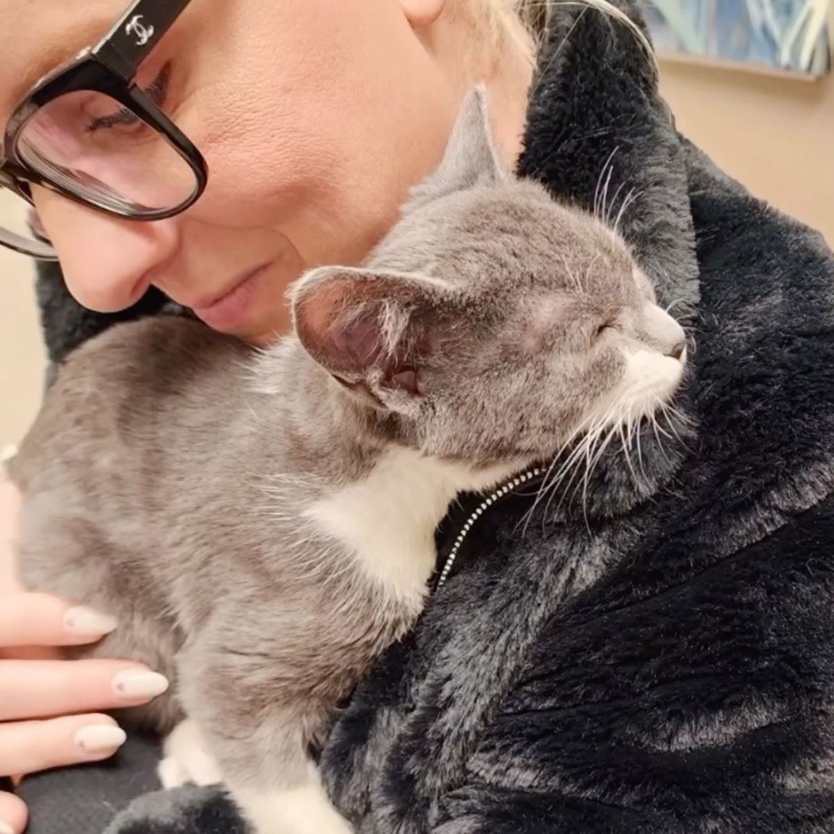 woman holding and petting a cat