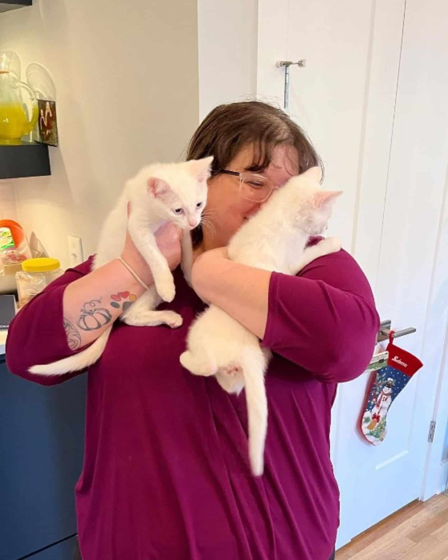 woman hugging cats