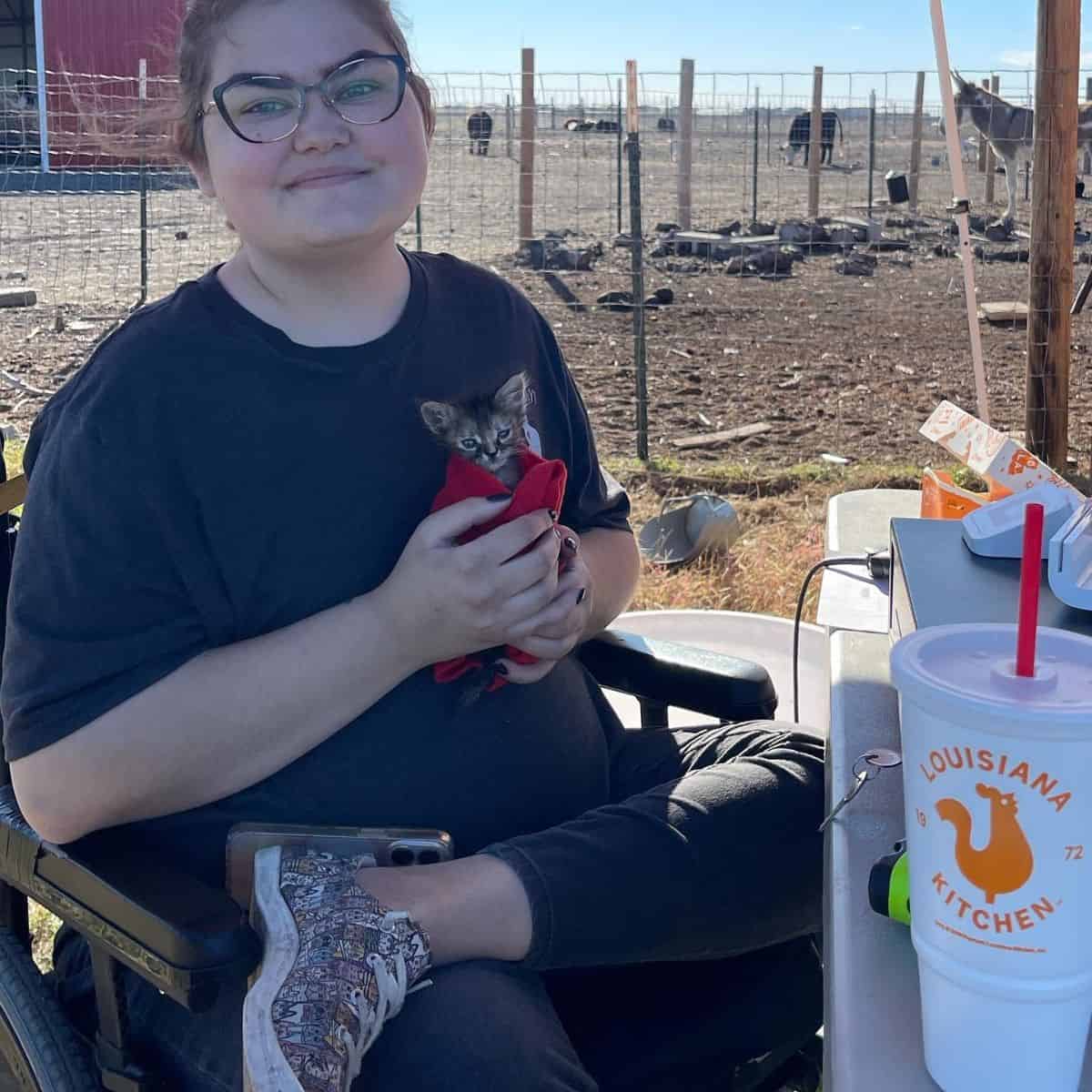 woman sitting outside and holding the kitten