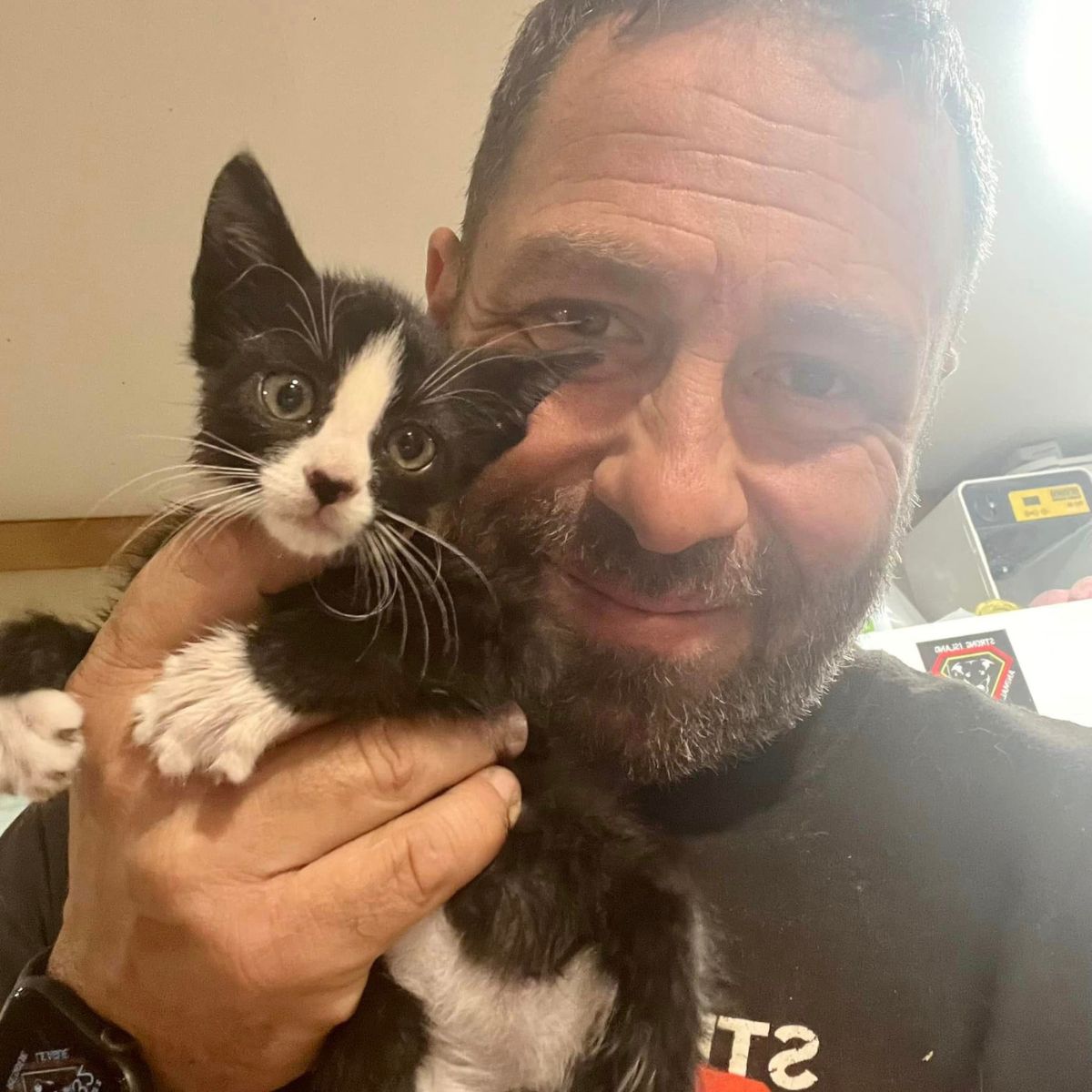 man holding a rescued kitten