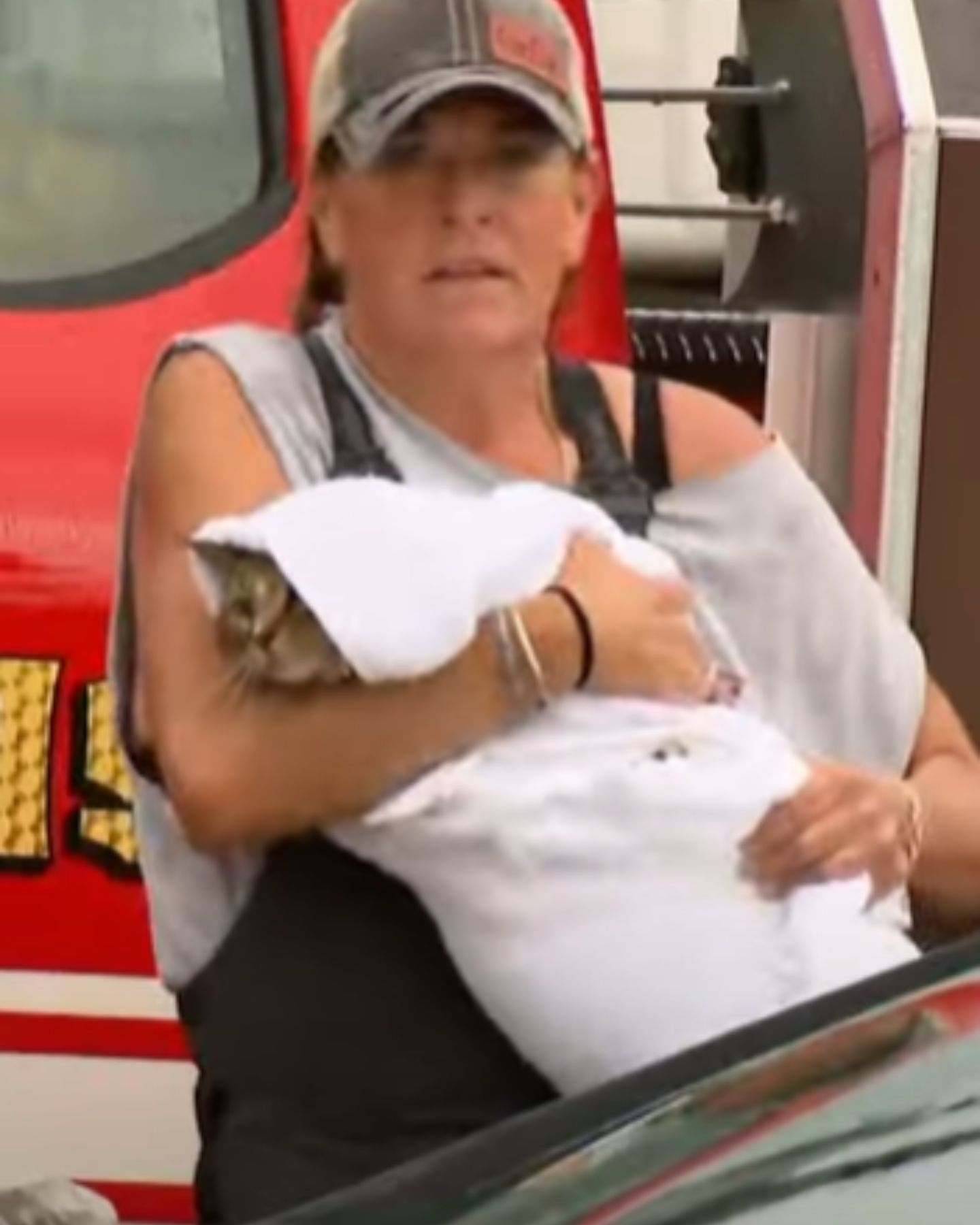 woman carrying cat in blanket