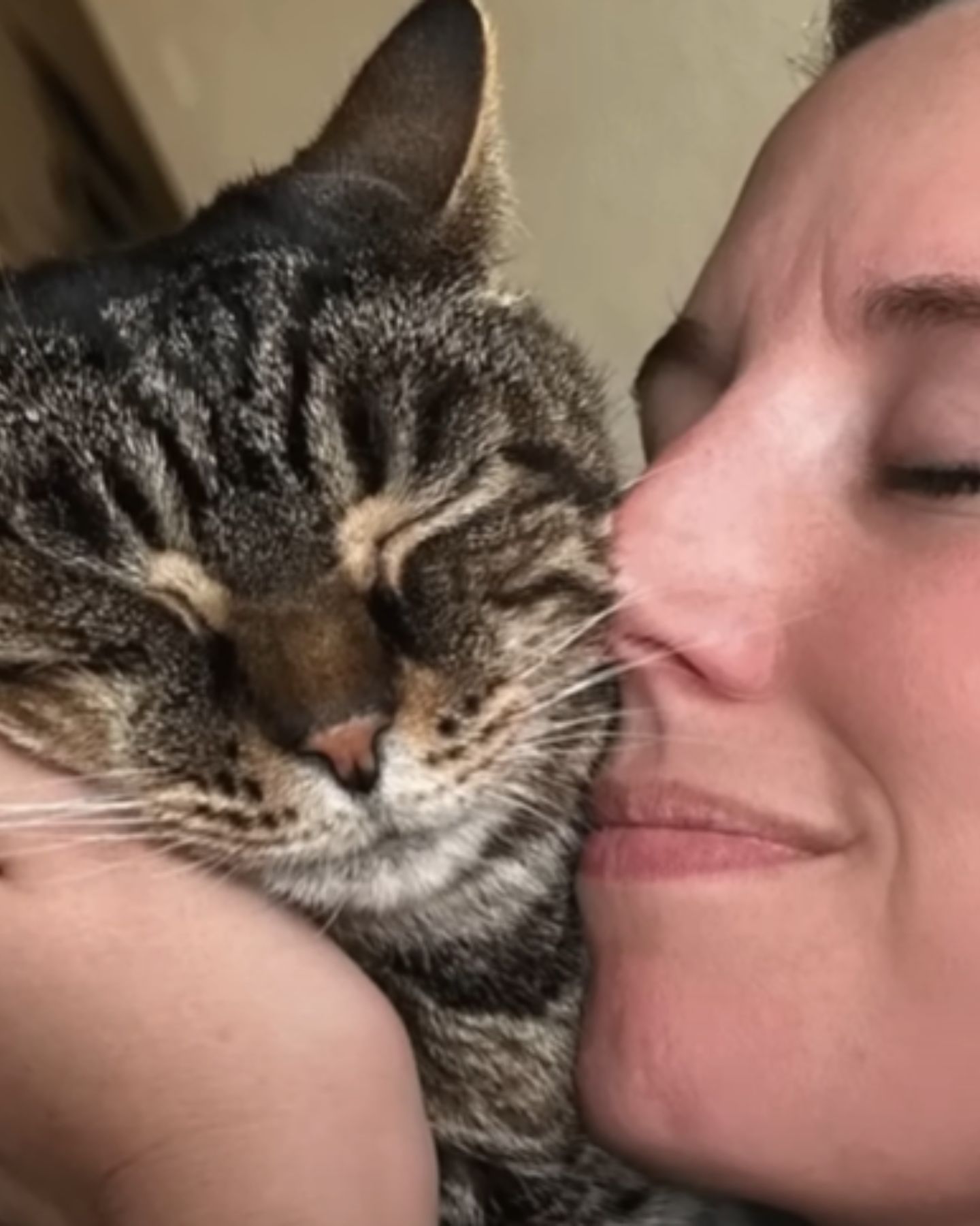 woman snuggling with cat